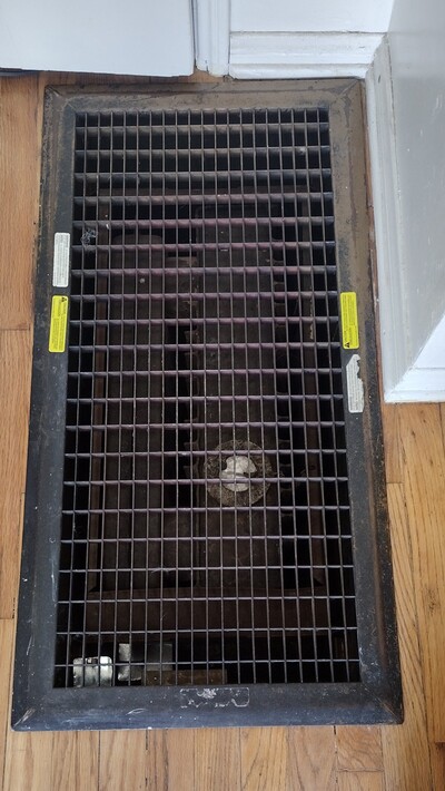 Floor furnace heating grate installed in hardwood flooring, common in older Southern California homes.