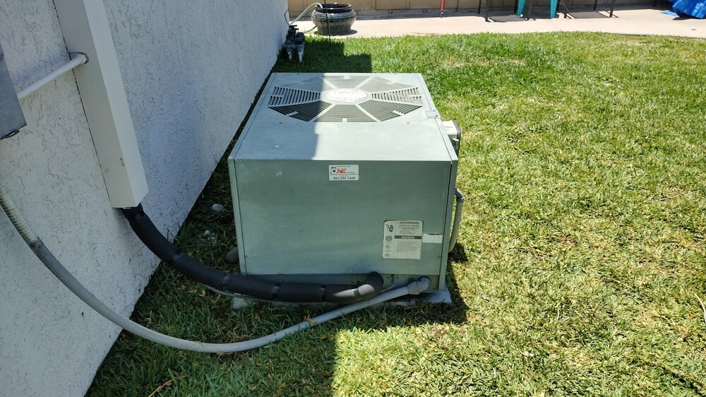 Installed air conditioning condenser unit in residential Lakewood backyard with Dial ONE Schilling brand label.