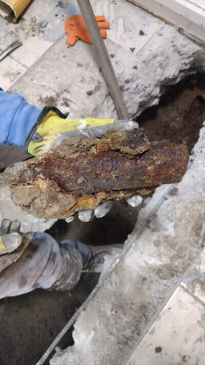 Severely corroded and rusted pipe section removed during plumbing repair in Lakewood home.