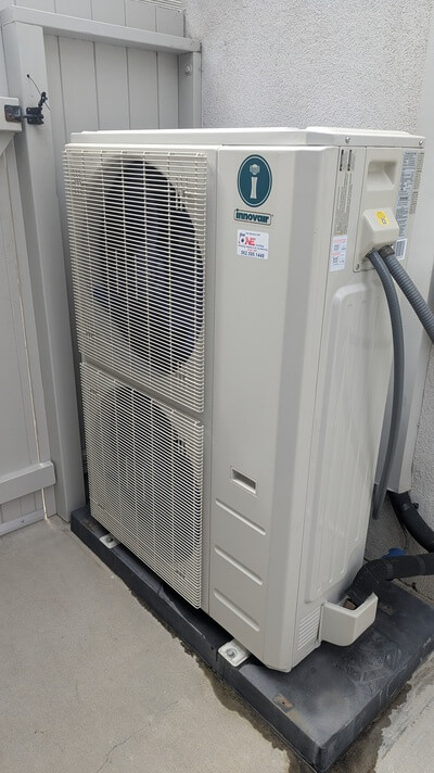 Outdoor Innovair air conditioning condenser unit on concrete slab.