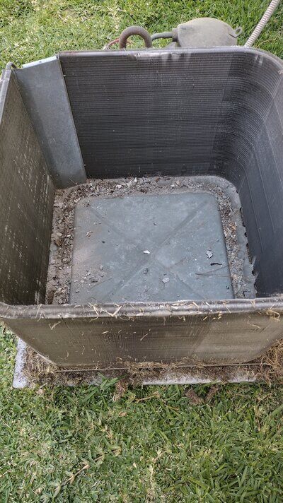 Dirty and worn AC condenser coil removed from housing.
