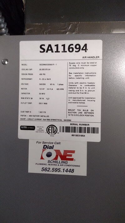 Furnace system label with model details and Dial ONE Schilling service sticker.
