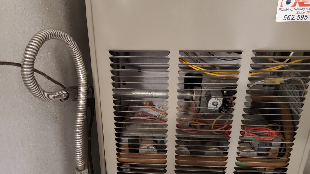 Close-up of HVAC furnace wiring and gas line connection with Dial ONE Schilling label.