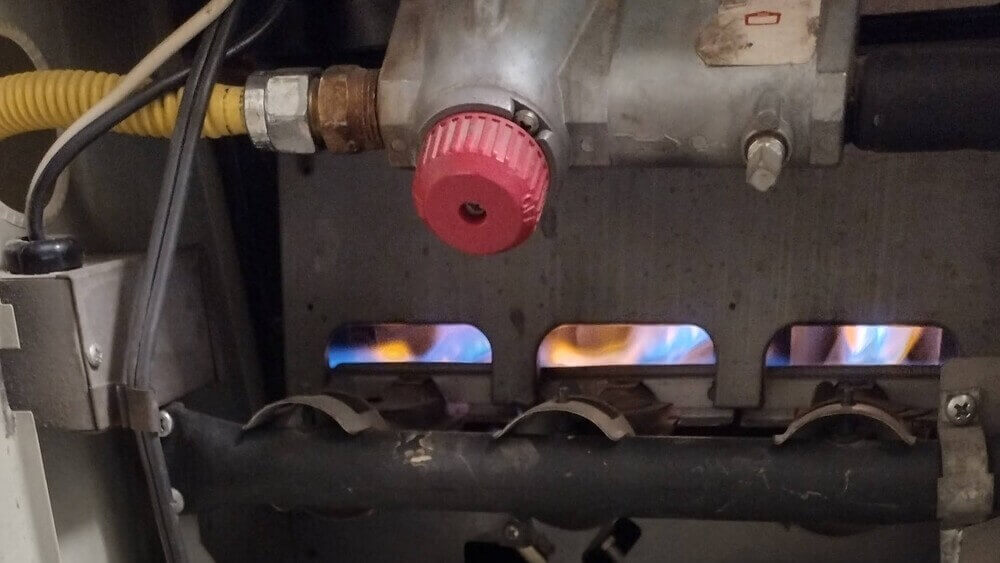 Gas furnace burner flames during heating system operation near Los Alamitos, CA.