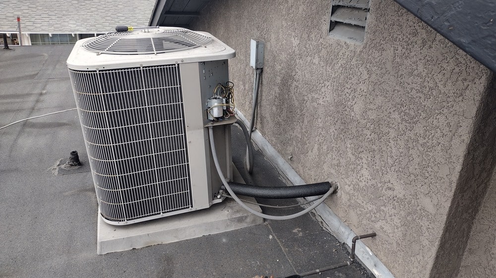 Rooftop HVAC condenser and refrigerant lines installed by Dial ONE Schilling for residential cooling.