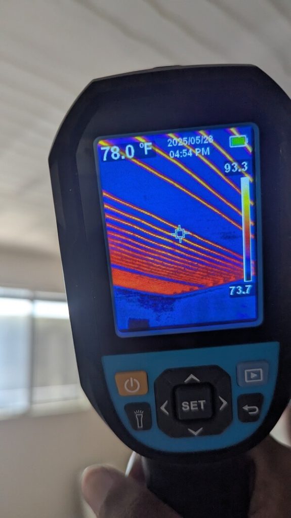 Thermal camera reading showing active radiant ceiling heat lines during diagnostic testing by Dial ONE Schilling.