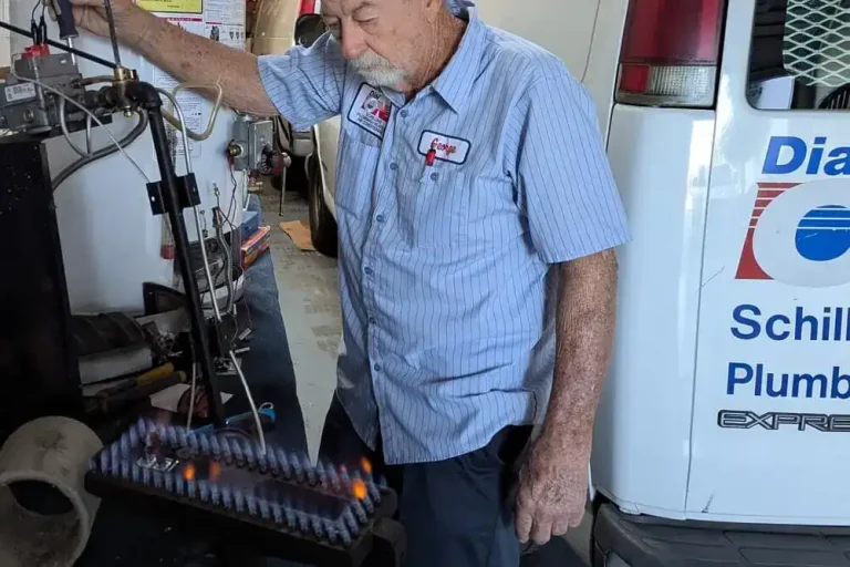 Dial ONE Schilling owner servicing a gas furnace burner assembly with visible flames.