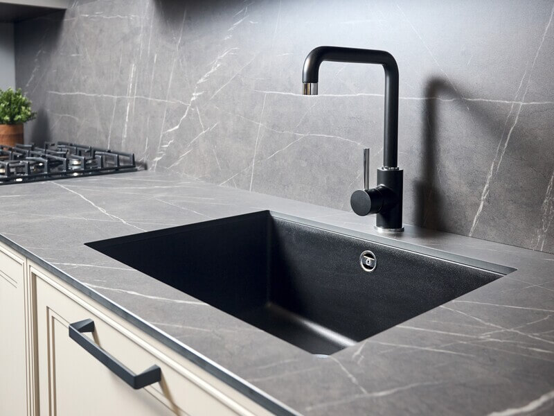 Modern undermount kitchen sink with black faucet and gray stone countertop